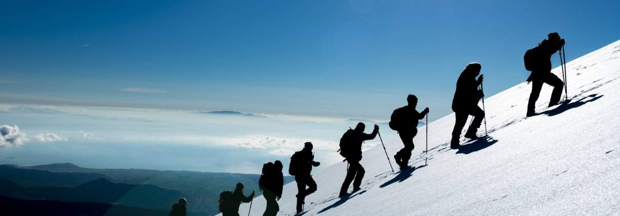 Hikers climbing a mountain full of snow