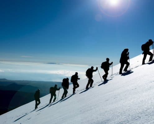 Hikers climbing a mountain full of snow