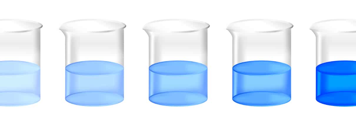 3 beakers of blue liquid on a white table