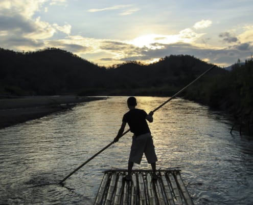guy on a boat paddling downstream